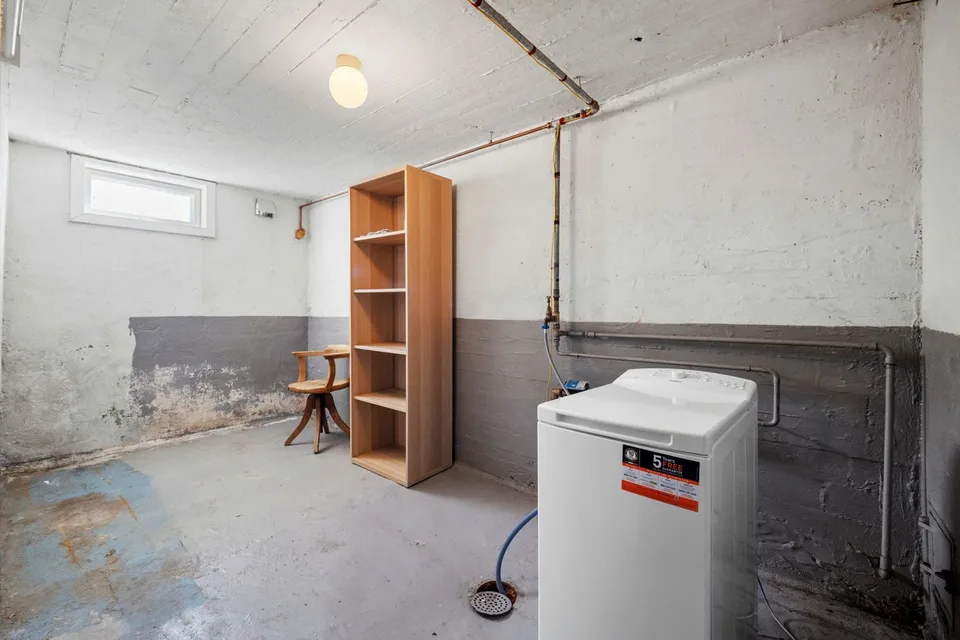 Uinnredet kjellerrom med synlige rør før renovering