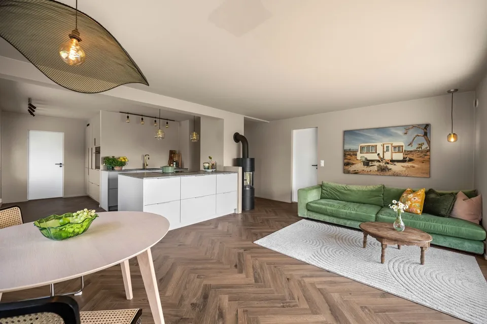 Åpen stue og kjøkken med kjøkkenøy etter renovering